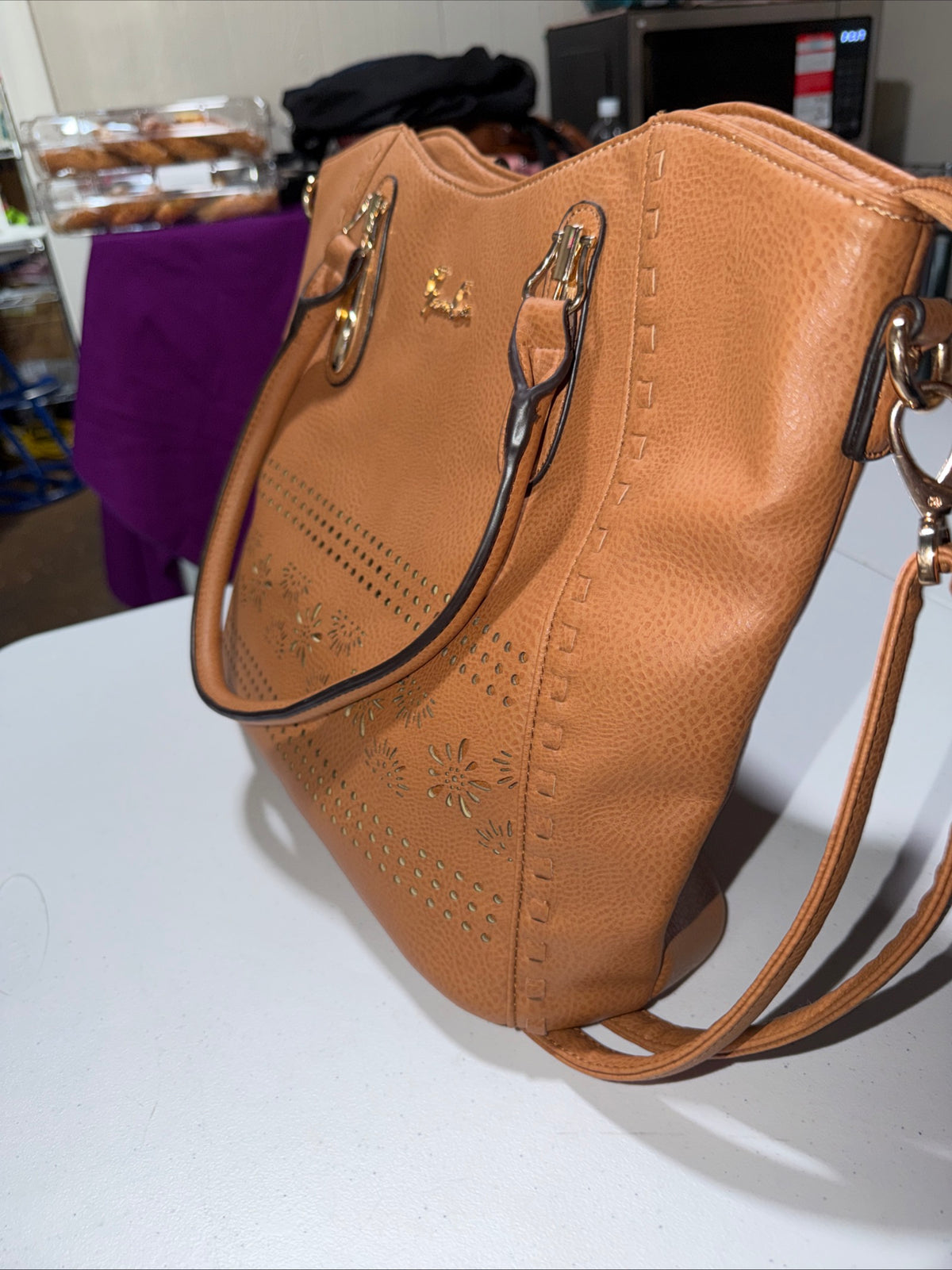 LerssaCi Tan Handbag With perforated floral cutouts and gold-toned hardware.