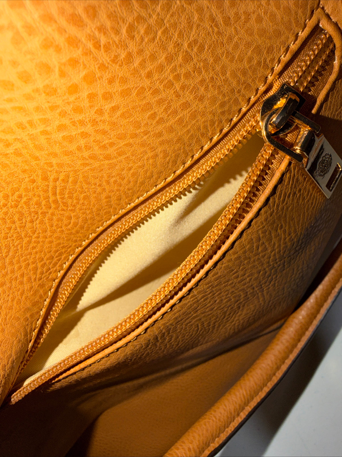 LerssaCi Tan Handbag With perforated floral cutouts and gold-toned hardware.